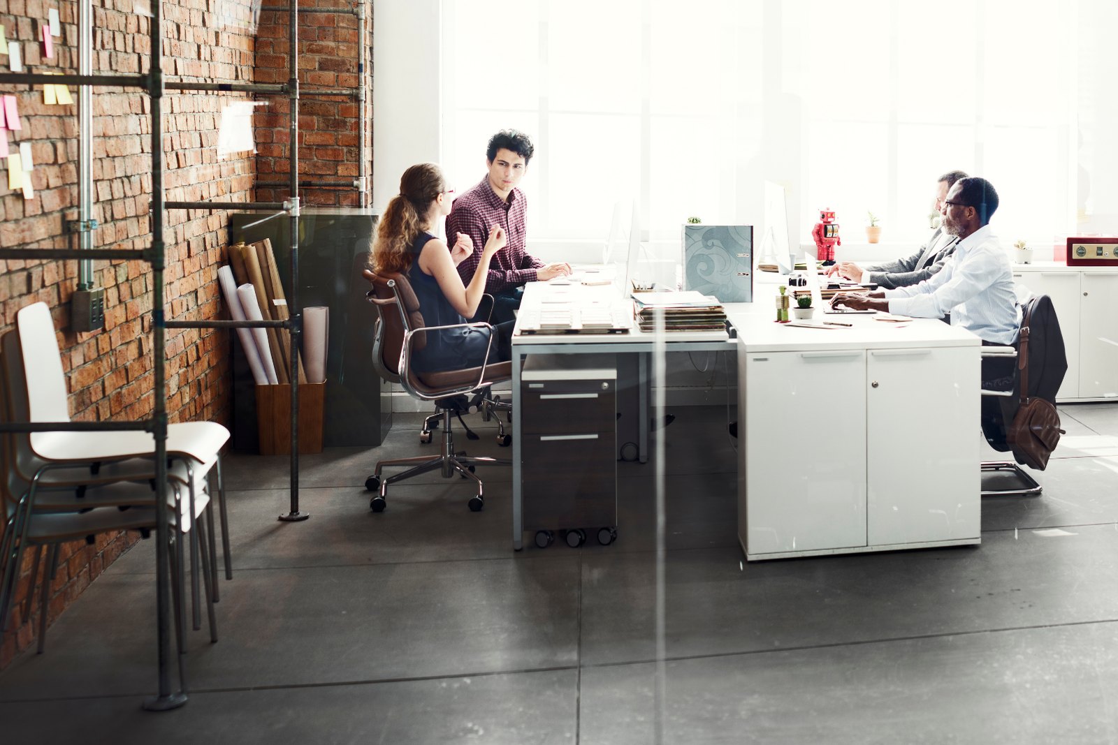 An open-plan office with people working at separate desks
